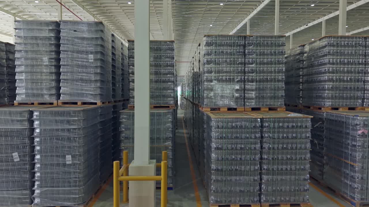 Aerial lateral shot of storage facility with pallets of beer bottles. Logistics center of brewery in Santo Domingo, Dominican Republic