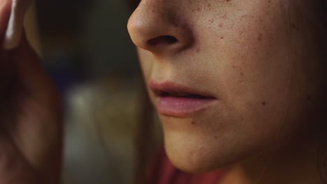 woman removing makeup from her face cleaning facial skin, portrait closeup