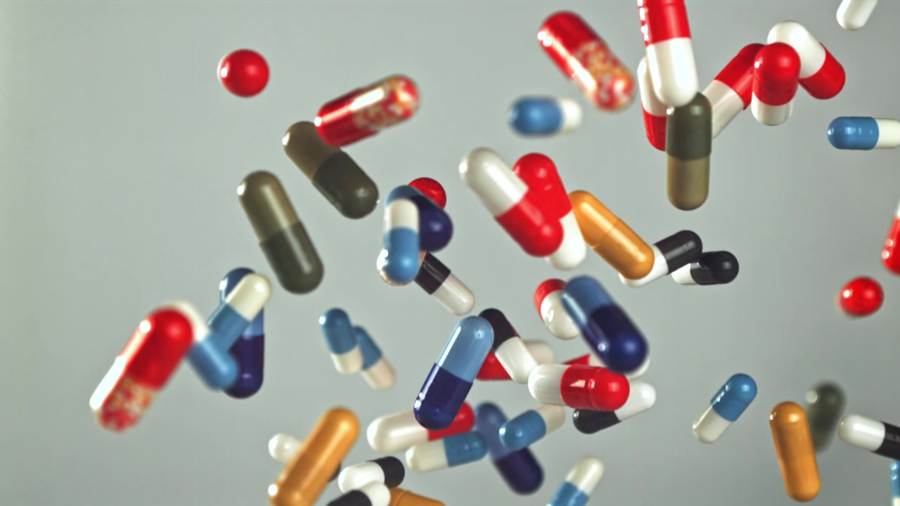 Colorful Pills and Capsules Falling in Slow Motion