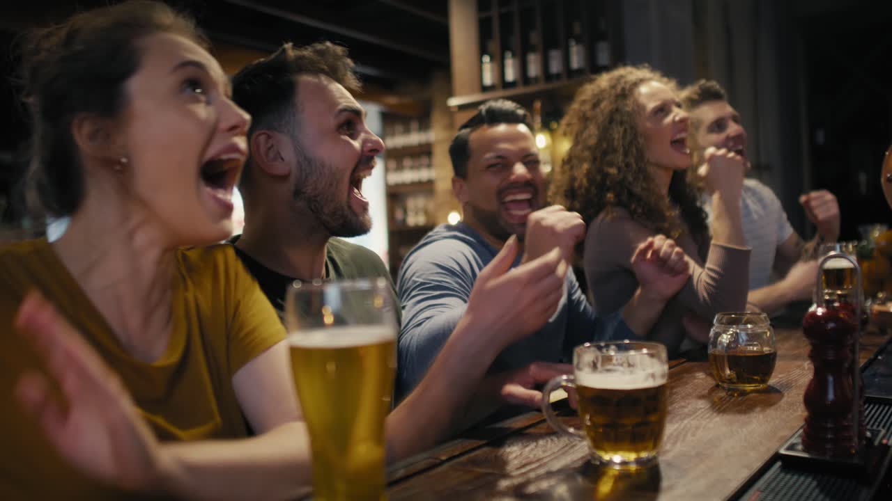 Gruppo di amici che fanno il tifo per una partita di calcio al pub