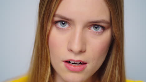 Closeup-serious-attractive-woman-looking-at-camera-on-grey-background.