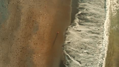 Drone-above-runner-on-the-beach-in-Bali,-Indonesia