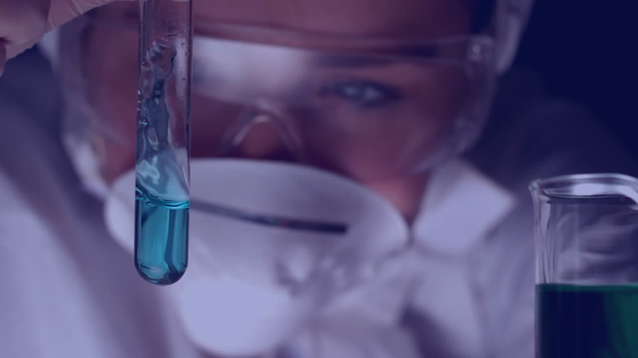 A scientist is swirling blue liquid in a test tube in slow motion