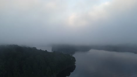 Die-Kamera-Erhebt-Sich-Aus-Dem-Wasser-Des-Sees-Durch-Eine-Nebelwolke,-Um-Den-Hellen-Sonnenaufgang-Zu-Enthüllen