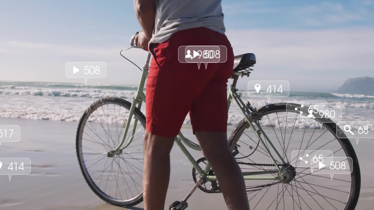 Uomo in piedi sulla riva che attiva icone multimediali, spingendo una bicicletta sulla sabbia e mostrando metriche di marketing