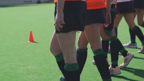 female hockey players exercising on the field