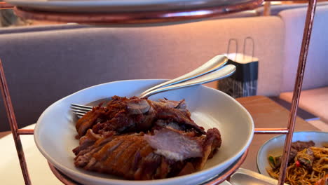 traditional crispy peking duck with steamed pancakes, onion, cucumber, hoisin sauce and sriracha sauce, tasty asian dish served on a three floor tray tower, 4k shot