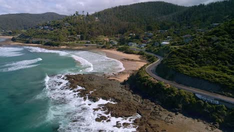 White-car-and-caravan-drive-along-famous-Great-Ocean-Road-near-Wye-River-and-Separation-Creek,-Victoria,-Australia