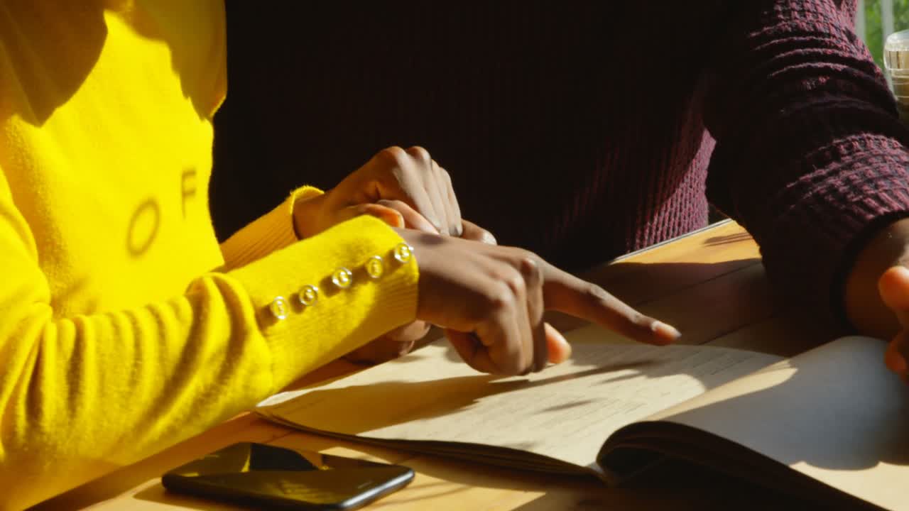 pareja discutiendo sobre la tarjeta del menú en el café 4k