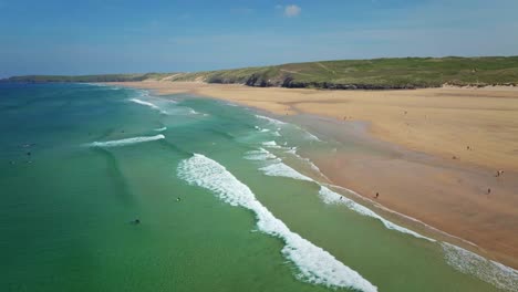 Surfer-Am-Strand-Von-Perranporth-Reiten-Auf-Türkisfarbenen-Wellen-Entlang-Der-Atemberaubenden-Küste-Von-Cornwall,-Großbritannien