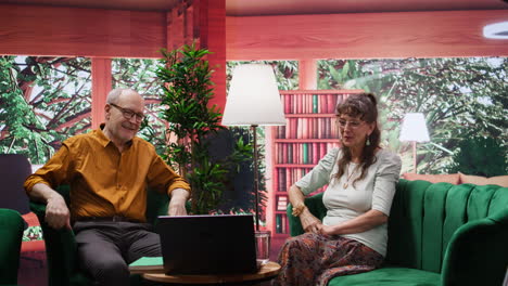 un hombre y una mujer ancianos saludando a sus nietos en una videoconferencia en línea