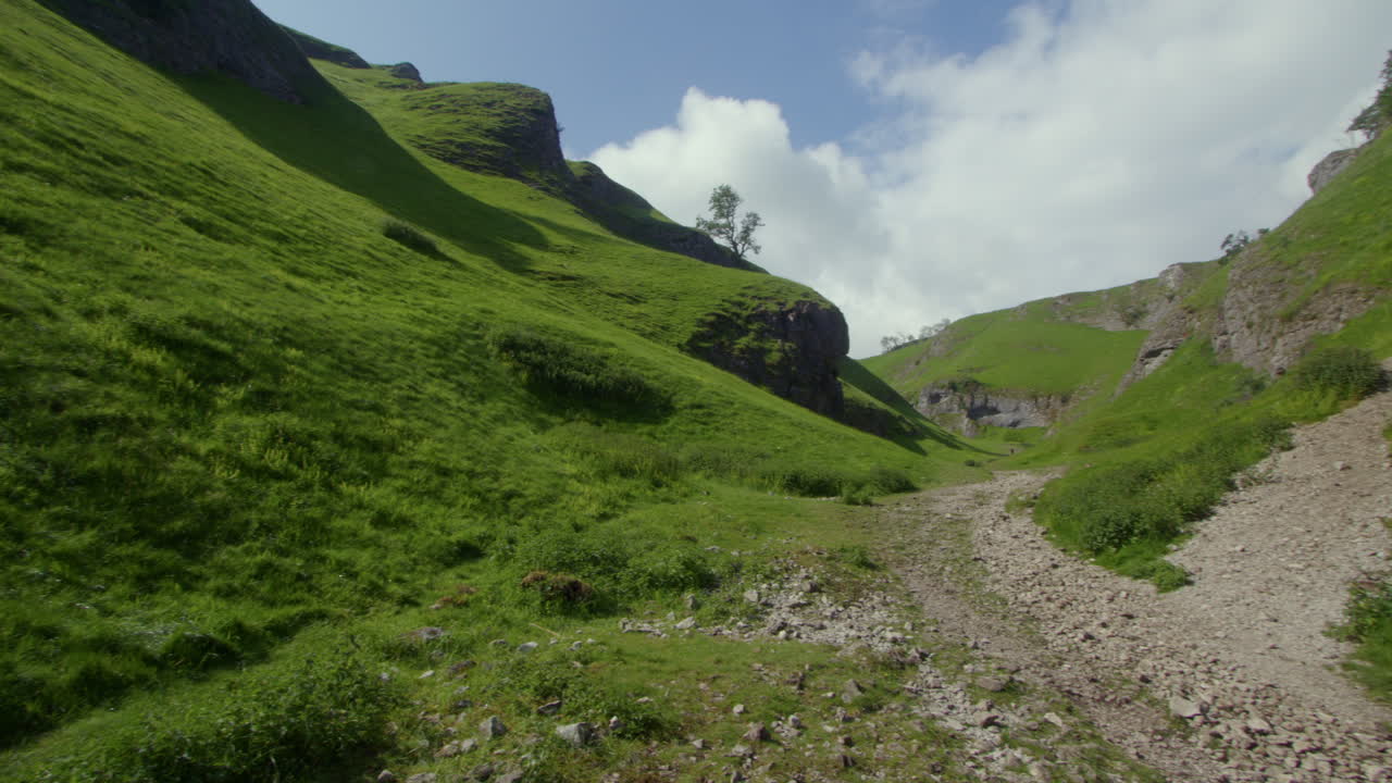 Green Valley with Rocky Path and Steep Slopes