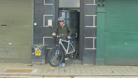 cyclist exits apartment and cycles out of frame