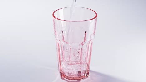 pure water poured into glass closeup with slow motion