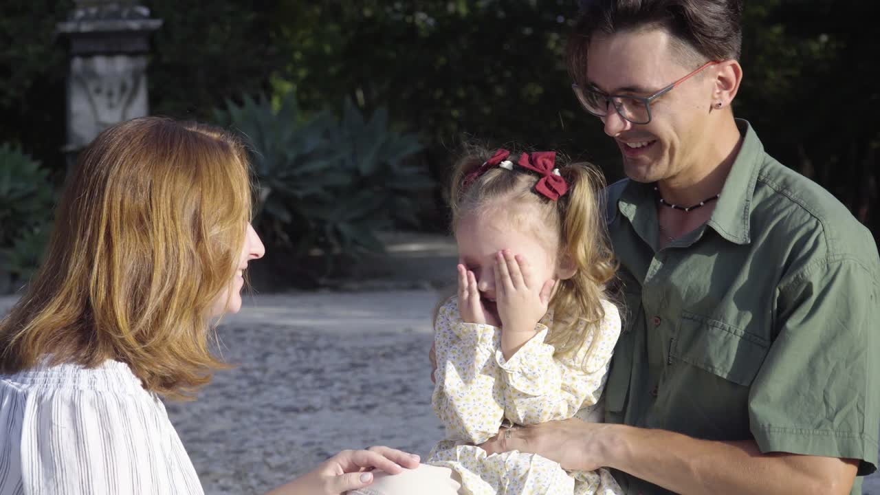 행복 한 젊은 부모 들 이 딸 과 함께 야외 에서 즐거움 을 누리고 있다