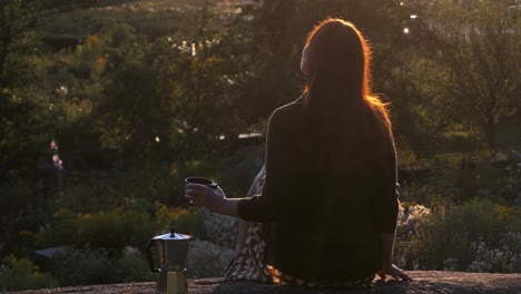 woman sitting on rock at sunset garden background