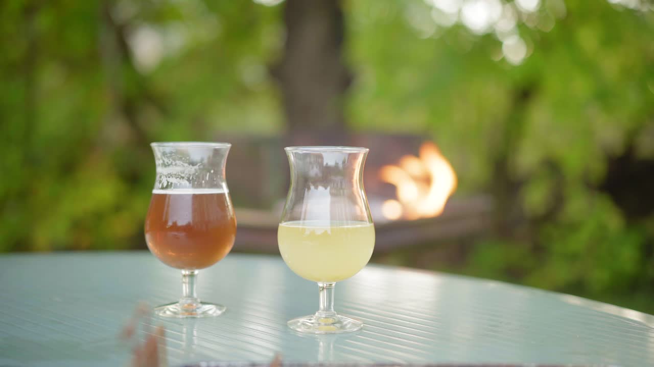 Cold beers on a picnic table while a fire is burning for a barbecue, summer BBQ party on a sunny day