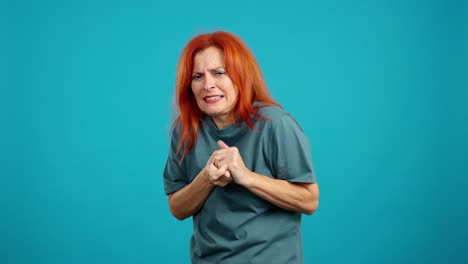 woman with red hair expressing discomfort and pain against a blue background