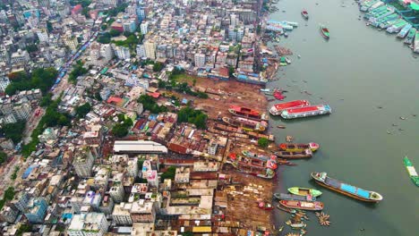 Dense-aerial-shot-of-Dhaka-City,-and-Buriganga-River-with-busy-shipping-dockyard---Bangladesh