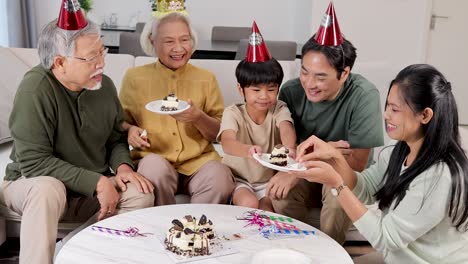 a joyful family gathering with grandparents, parents, and child sharing a birthday cake in a festive setting