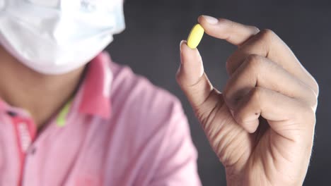 person holding a yellow pill