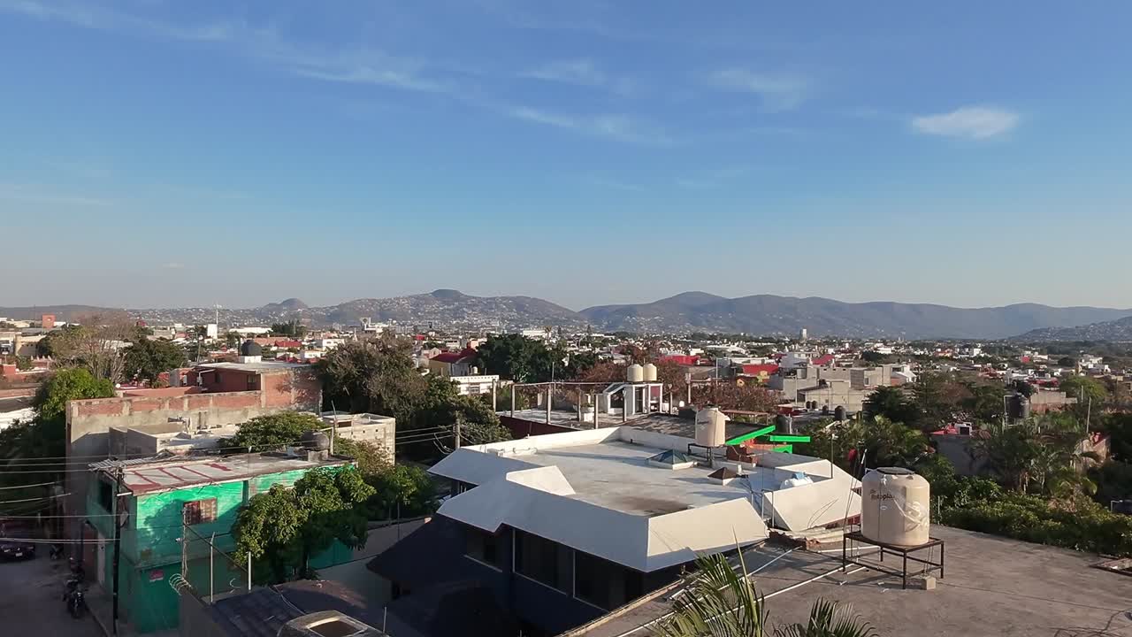 Rooftops in jiutepec, featuring a clear sky and distant mountains , aerial view