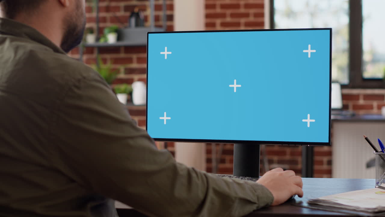 Company manager looking at computer with greenscreen
