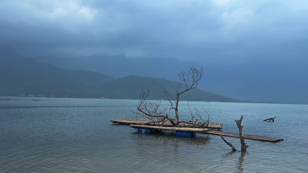Wooden Raft Floating With Dried Tree Isolated Over Tropical Calm Lake. Pan Right Shot