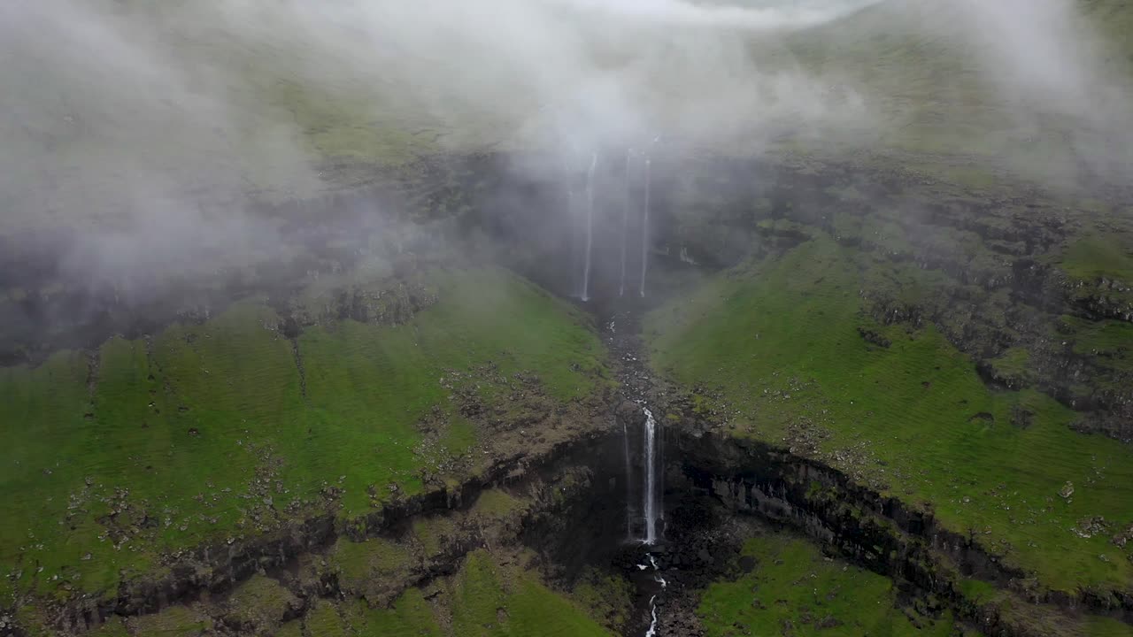 catarata de fossá en las islas feroe, bajando la revelación aérea a través de las nubes