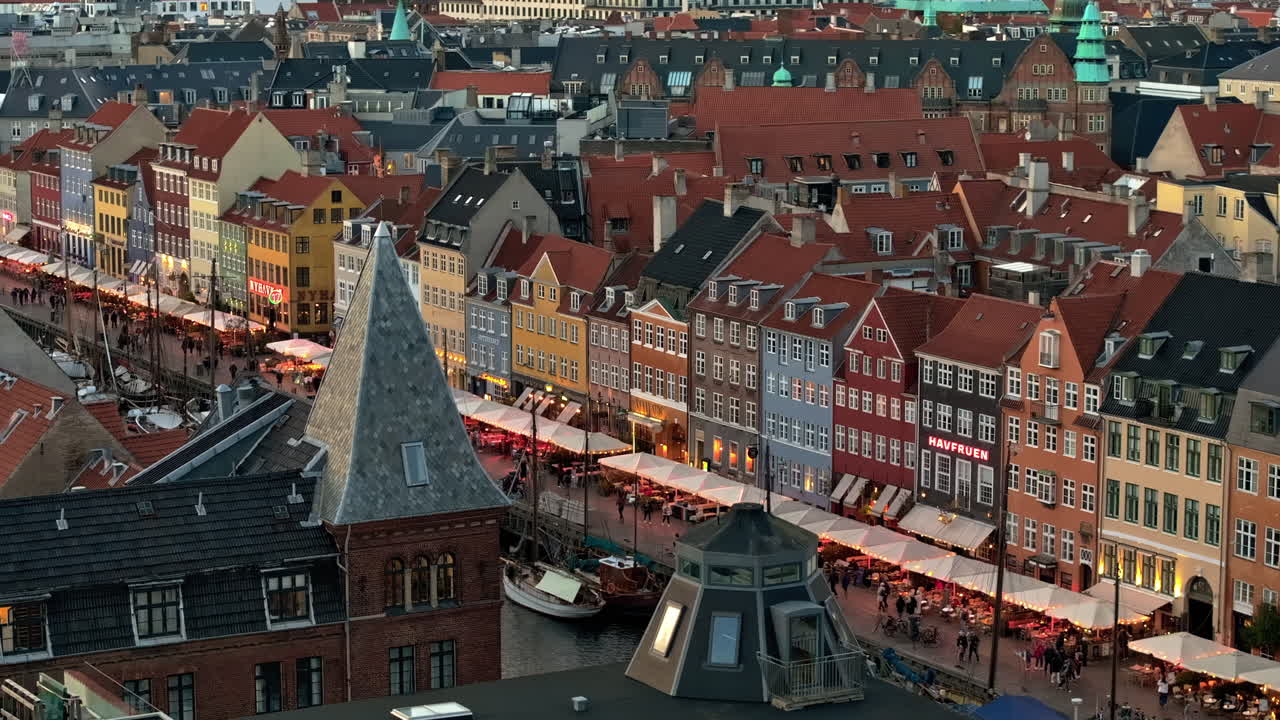 Aerial drone view of the Nyhavn waterfront, canal and entertainment district in Copenhagen, Denmark in the evening