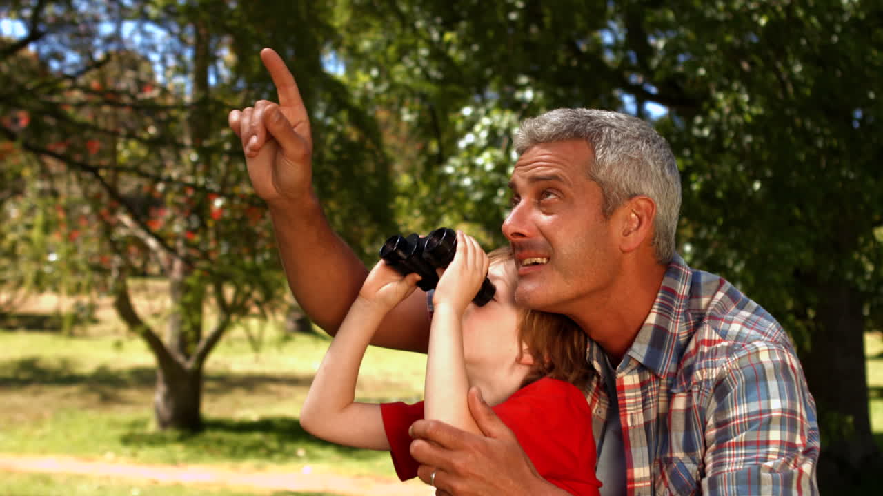 padre e hijo usando binoculares en el parque