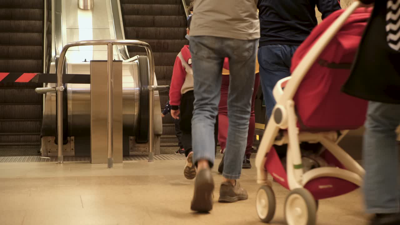 People using a moving staircase in a metro station
