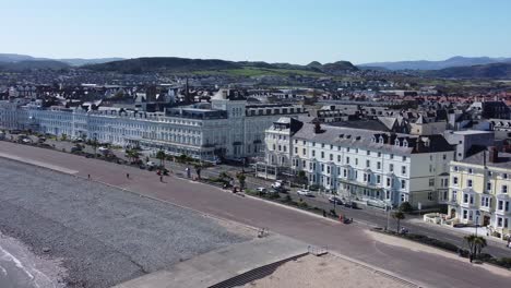 llandudno coastal seaside town hotels on beachfront promenade aerial view wide orbit left