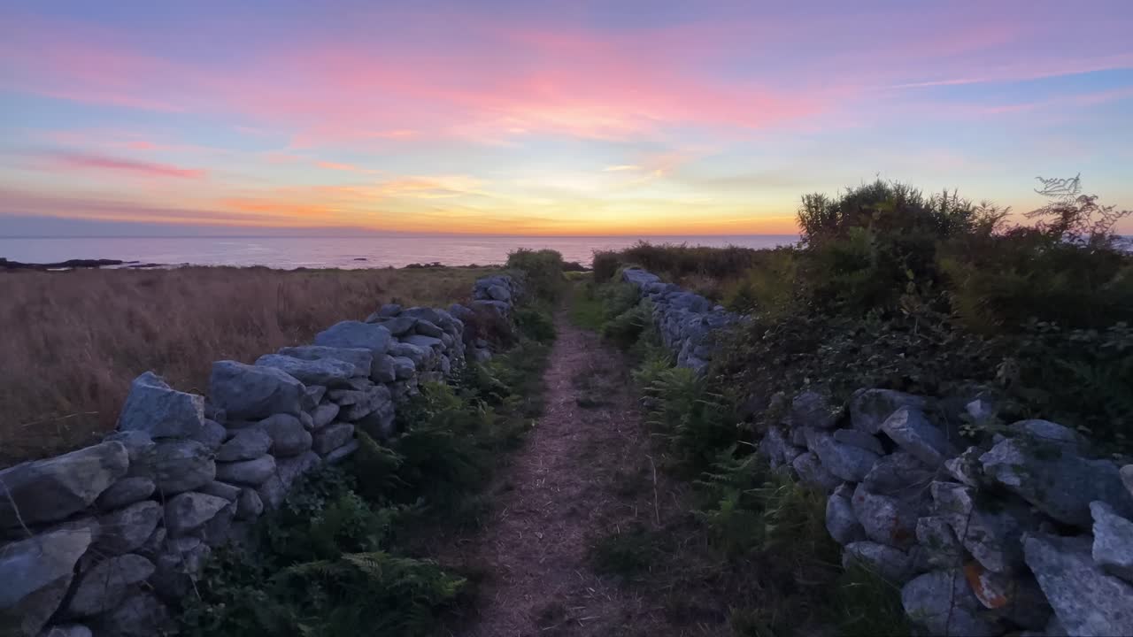 Path with Two Stone Fences Leading to Ocean During Sunset