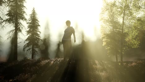 young woman standing alone outdoor with wild forest mountains