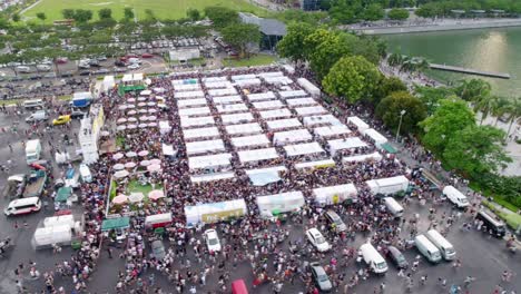 carnival and fair in singapore with thousands of people aerial shot with camera tracking right and holding