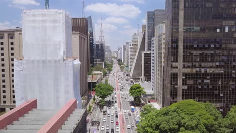 Sao-Paulo-city-center-crossroad-on-a-sunny-day-Avenida-Paulista-in-Brazil,-static-aerial-footage-of-the-street