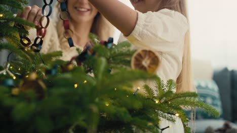 Kaukasisches-Kleines-Mädchen-Und-Mutter-Schmücken-Weihnachtsbaum-Mit-DIY-Papierkette.