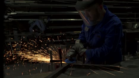 Anonymous-workman-welding-metal-construction-in-workshop