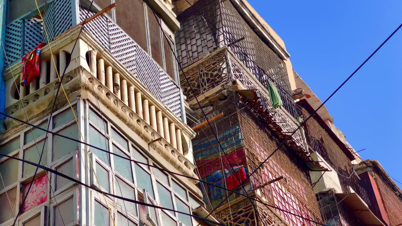Closeup shot of heritage building with black communication wires in foreground in Sadar of Karachi, Pakistan