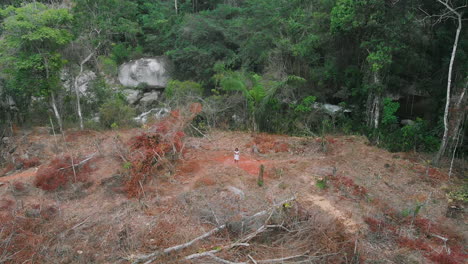 native person in the middle of the deforestation