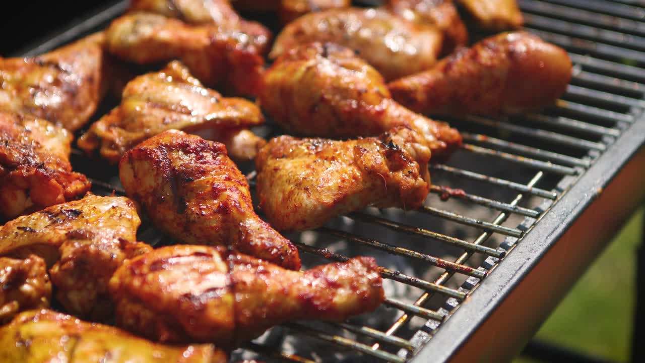 Delicious chicken pieces frying on barbecue grill