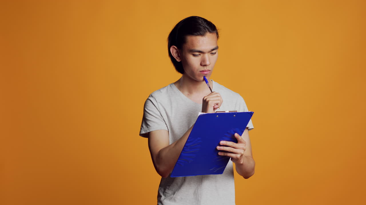 Confident young man writing and taking notes on files