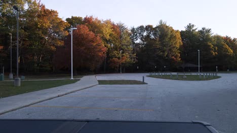 an empty parking lot in the middle of autumn