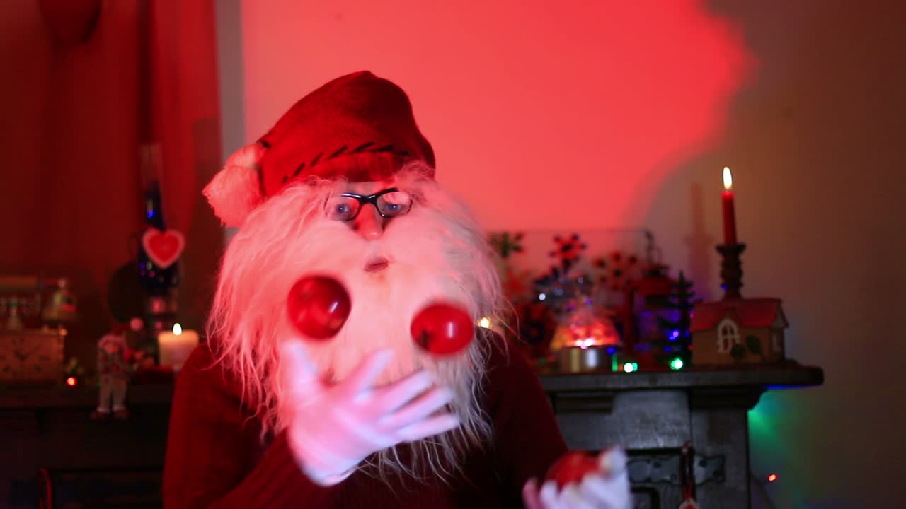 3개의 빨간 사과로 저글링하는 산타클로스