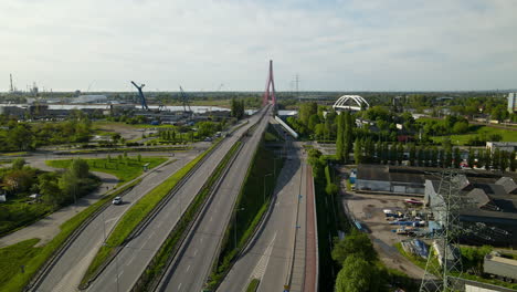 aerial - cars moving along the highway road through third millennium john paul bridge, cargo terminal on background, gdansk poland on sunny day