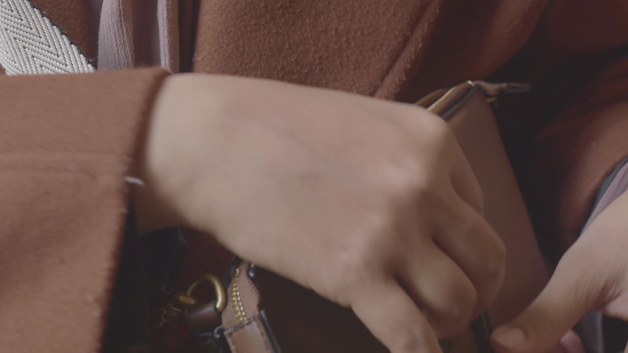 갈색 가죽 가방 을 열고 있는 여자 의 손 의 클로즈업