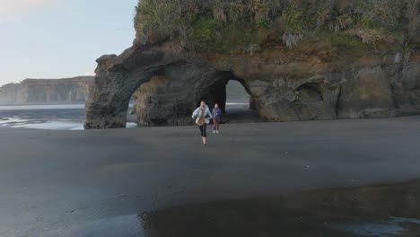 young couple running in three sisters beach at sunset