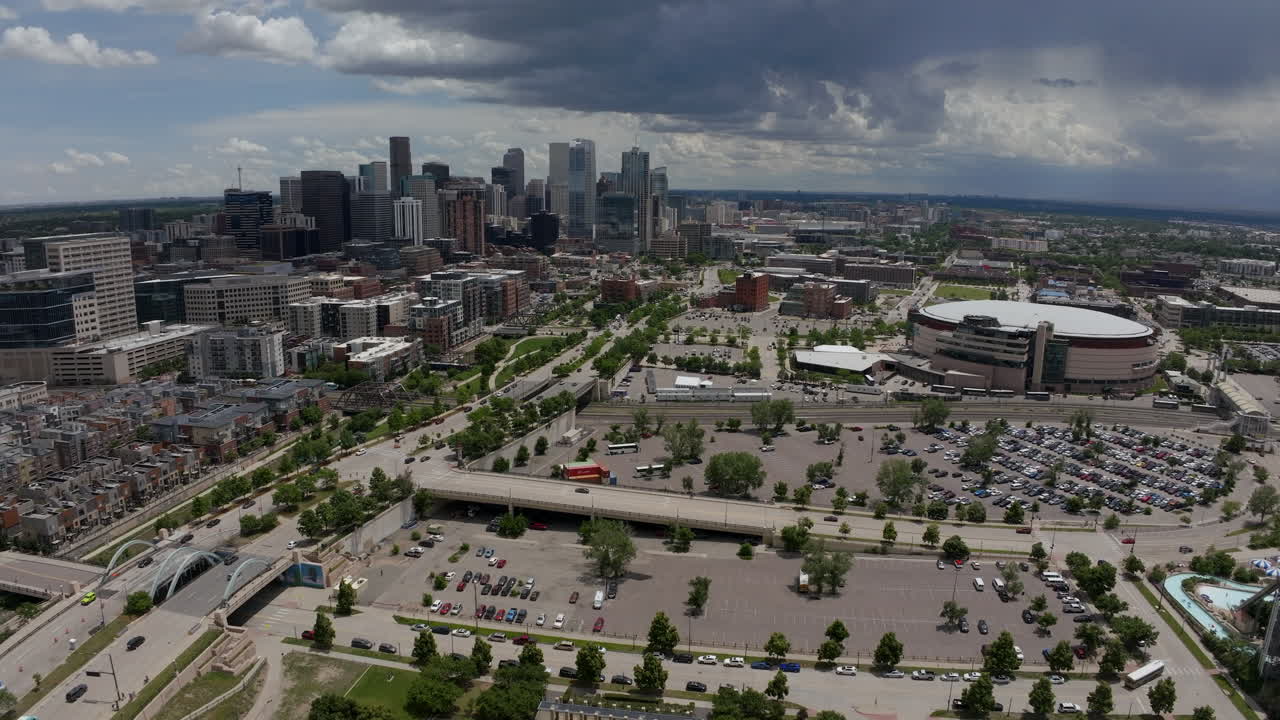 Downtown Denver Aerial Drone cinematic REI Ball Arena South Platte River Elitch Gardens cityscape with foothills Rocky Mountain Landscape Colorado cars traffic spring summer sunny forward movement