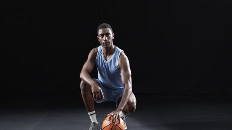 Un-Hombre-Afroamericano-Posa-Con-Confianza-En-Una-Cancha-De-Baloncesto-Con-Fondo-Negro